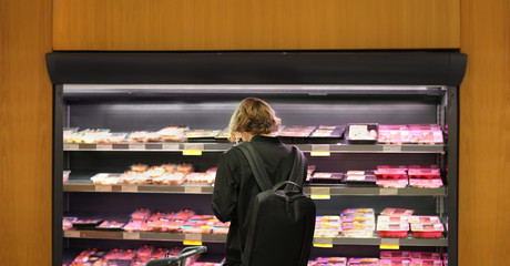 man purchasing a packet of meat at the supermarket