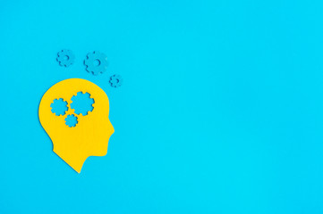 Brain works concept. Thinking, creativity concept of the human head with gears on blue background