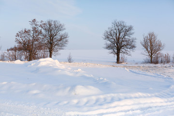 Winter poorly cleared road. Road in the countryside strewn with snow. Winter landscape with snowdrifts