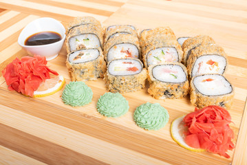 Set of baked rolls with various fillings. Close up with ginger and wasabi.