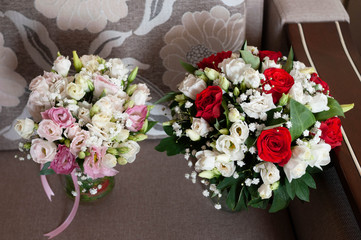 bridal bouqets with red, white, pink roses, green leaves and ribbon at home