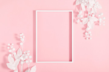 Christmas minimal composition. Photo frame and white decorations on pastel pink background. New Year, winter concept. Flat lay, top view, copy space