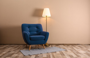 Comfortable armchair with floor lamp and rug indoors