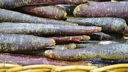 Colorful purple heirloom carrots at a farmers market