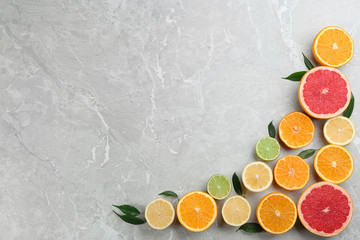 Flat lay composition with tangerines and different citrus fruits on grey marble background. Space for text