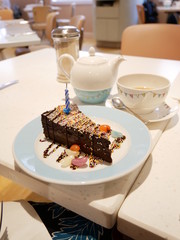 Chocolate Ganache Birthday Cake with Jelly Beans and Candle and Pot of Tea