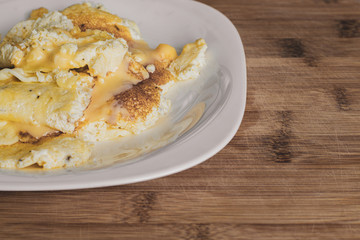 Tasty fresh omelet with melted cheese on a white plate