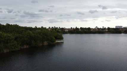 a dock on a lake in front of some trees and homes
