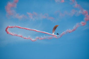 Motolotnia w powietrzu z biało-czerwonym dymem