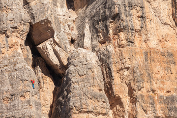 Rock climbers in action over a vertical cliff in the Cinque Torri area in Dolomites