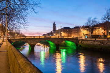 Four Courts and bridge over river Liffey illuminated at night in the city of Dublin in Ireland.