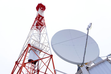 TV tower and satellite dish against the white sky