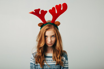 The red-haired girl was offended by her parents on Christmas evening. Blue-eyed cutie at friends with a New Year's gift. Teenage mood is changing. Separately on a white background. Family problems