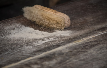 un cepillos csobre una mesa de madera escuadra de panadería con azucar 