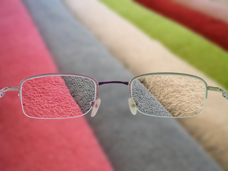 Glasses with thin frame on background of multicolored terry towel. Clear image through glasses and...