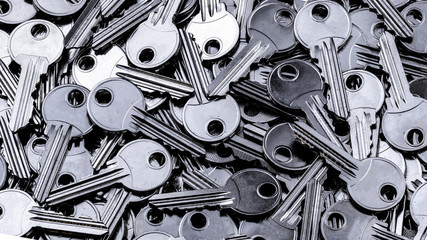Close up of a pile of keys. Gray industrial background.