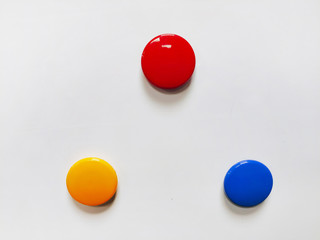 Round colored magnetic markers pinned to a white board with copy space