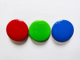 Round colored magnetic markers inline pinned to a white board close up