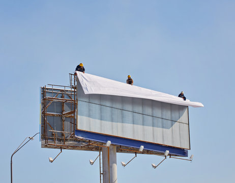 Worker Prepares Billboard To Installing New Advertisement.