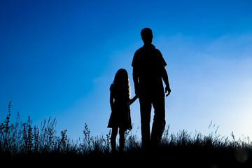 happy parent with child in the park outdoors silhouette