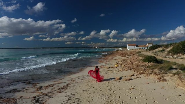 a girl in a red dress walks on the beach barefoot, es Trenc, Majorca Spain