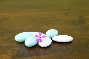 Confetti, in the foreground with a purple flower on a wooden table