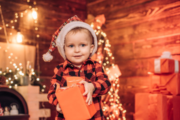 Fototapeta na wymiar Happy child with Christmas gift box. Surprise . Present box. A little boy in warm clothes.Merry Christmas and happy New year.