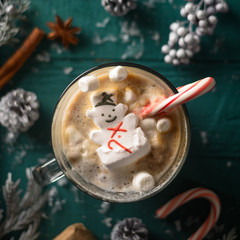 Christmas composition, mug with hot chocolate with melted snowman marshmallows and caramel. Square photo for instagram
