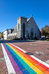LGBTQ+ Rainbow crosswalk in Gainesville Florida with a church in background on a sunny day
