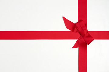 Layout made of red ribbon bow on white background. Mockup, flat lay. View from above, top,...