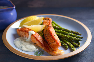 Salmon fish fillet with asparagus and creamy garlic sauce