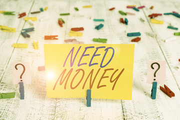 Writing note showing Need Money. Business concept for require a financial assistance to sustain spending or endeavor Crumbling sheet with paper clips placed on the wooden table