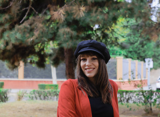 Beautiful young woman with red jacket and black cap