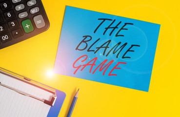 Writing note showing The Blame Game. Business concept for A situation when showing attempt to blame one another Clipboard blank sheet square page calculator pencil colored background