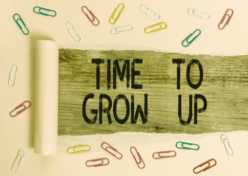 Conceptual hand writing showing Time To Grow Up. Concept meaning knowing that you are mature demonstrating have responsibility Paper clip and torn cardboard on wood classic table backdrop