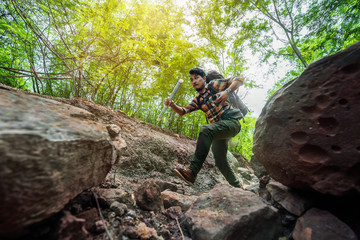 Fototapeta premium man traveler with backpack running in the forest