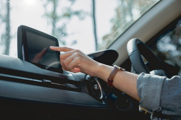 Closeup image a woman using and pointing finger at navigation screen while driving car