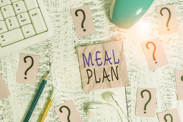 Conceptual hand writing showing Meal Plan. Concept meaning arrangement scheme of what are going to eat next week month Writing tools and scribbled paper on top of the wooden table