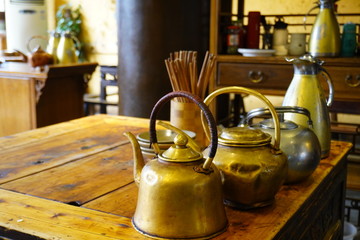 The traditional old school kettles in the restaurant on wooden table.