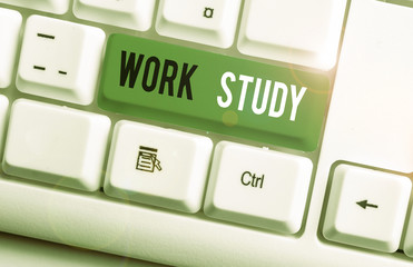 Writing note showing Work Study. Business concept for college program that enables students to work parttime White pc keyboard with note paper above the white background