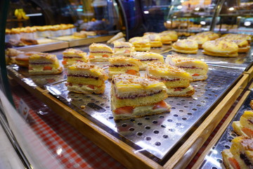 Delicious fruits sandwich in a bakery shop with strawberry with fresh cream, blueberry sauce and fluffy sponge cake.