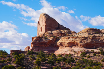 Close up of a towering red rock vertical faced cliff in the heart of Canyonlands National Park in Utah.