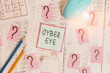 Word writing text Cyber Eye. Business photo showcasing tool engages in building smart technologies in cybersecurity Writing tools, computer stuff and scribbled paper on top of wooden table