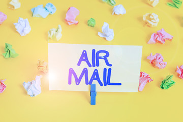 Handwriting text writing Air Mail. Conceptual photo the bags of letters and packages that are transported by aircraft Colored crumpled papers empty reminder white floor background clothespin
