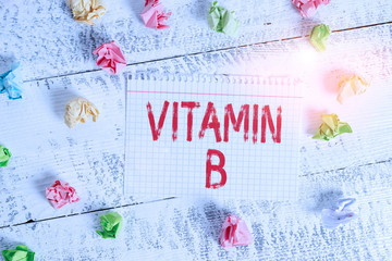 Handwriting text writing Vitamin B. Conceptual photo Nutrient that helps keep the body nerve and blood cells healthy Crumpled colored rectangle square shaped paper reminder white wood desk