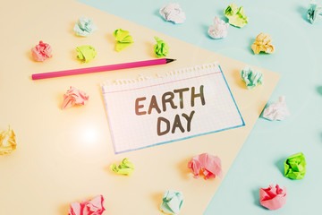 Word writing text Earth Day. Business photo showcasing Worldwide celebration of ecology environment preservation Colored crumpled papers empty reminder blue yellow background clothespin