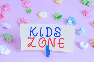 Word writing text Kids Zone. Business photo showcasing An area or a region designed to enable children to play and enjoy Colored crumpled papers empty reminder pink floor background clothespin