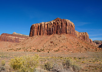 Fototapeta premium A natural red rock fortress reaches toward the brilliant blue sky in Canyonlands National Park.