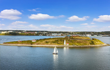 Fototapeta na wymiar Panoramic view of Halifax Harbor with lighthouse on island and sail boat on sunny day