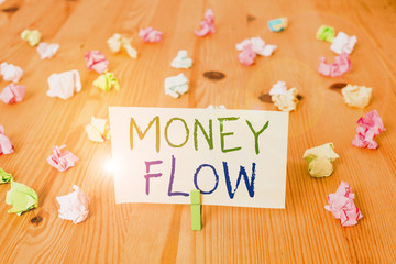 Conceptual hand writing showing Money Flow. Concept meaning the increase or decrease in the amount of money a business Colored crumpled papers wooden floor background clothespin